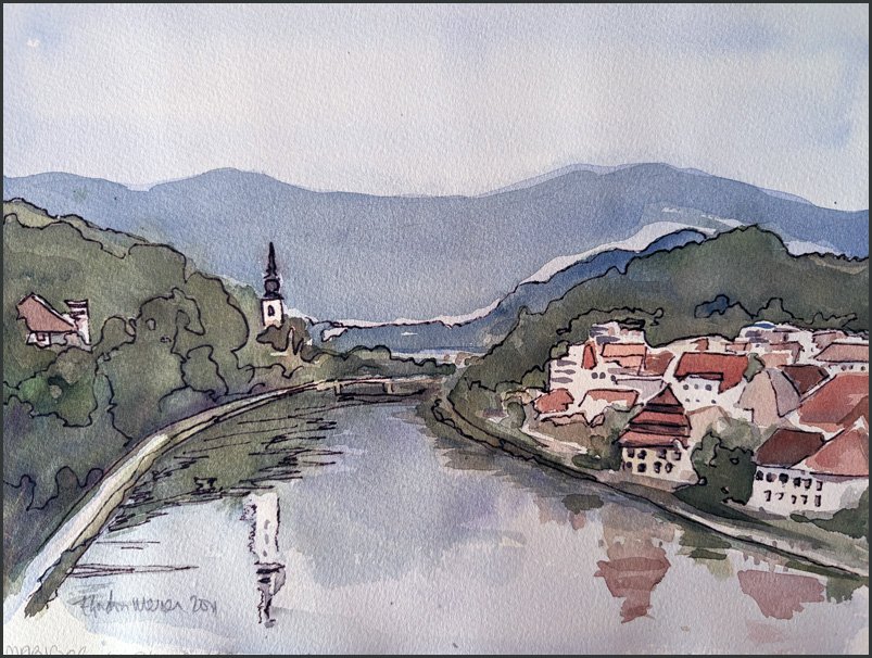 Red roofs of Maribor and a white church steeple reflected in the Drava river.