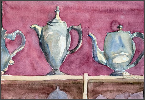 A row of three silver teapots on a shelf